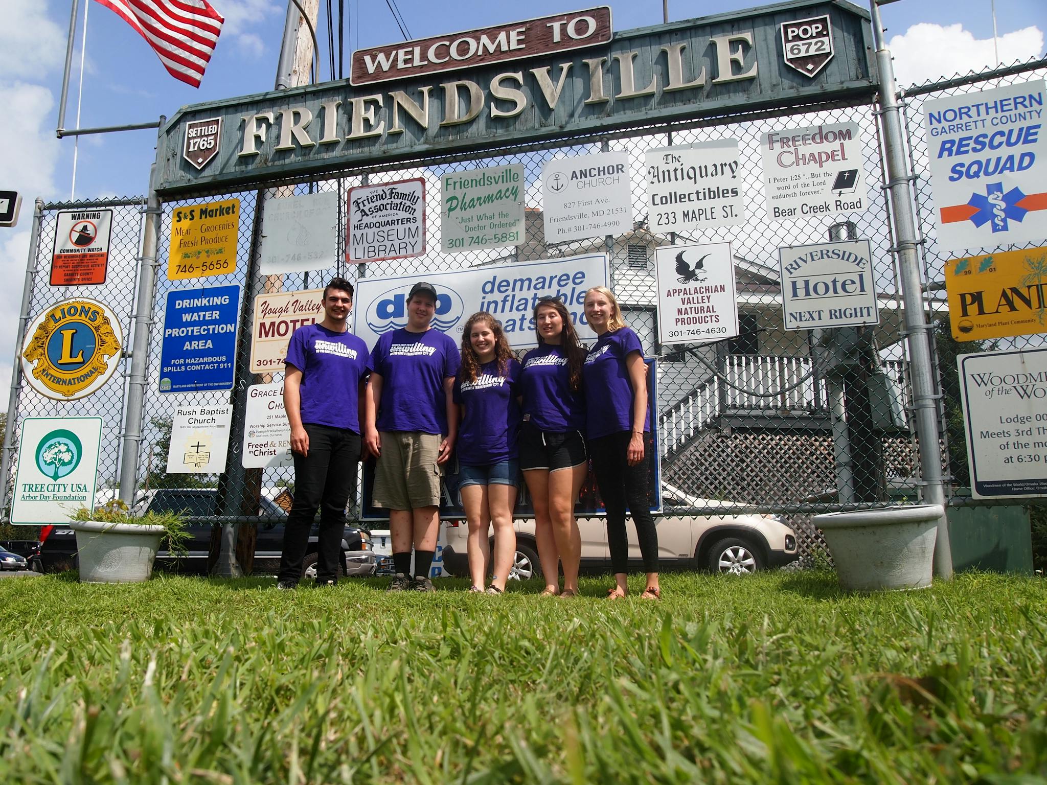 Group photo in front of a sign that reads FRIENDSVILLE in Friendsville, Virginia